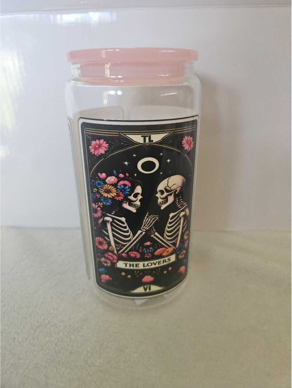 16 oz glass cup with acrylic Lid. Featuring skeletons and flowers.